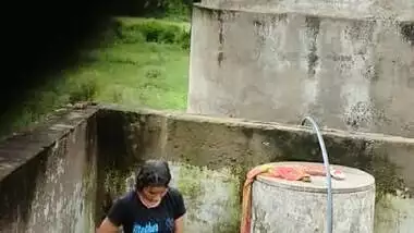 Indian village girl bathing near water tank outdoor