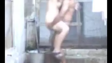 an indian lady taking her bath outside
