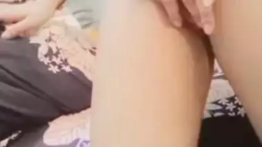 The naked girl fingers her wet pussy during a video call sex